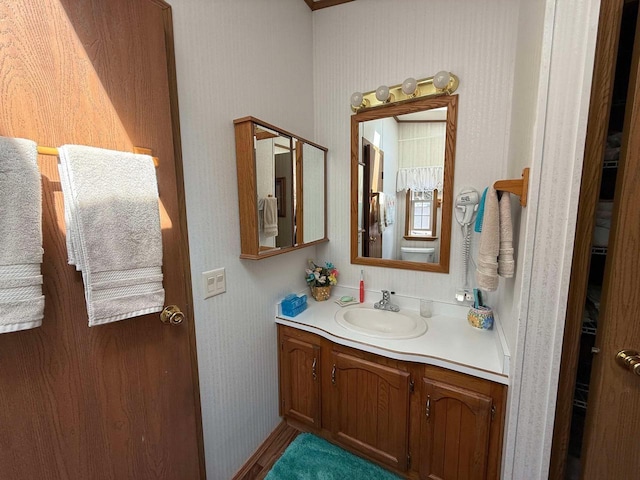 bathroom featuring vanity and wallpapered walls