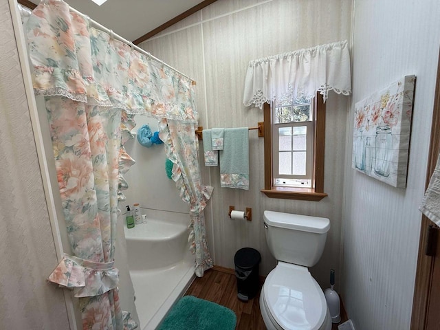 full bathroom featuring curtained shower, toilet, wood finished floors, and vaulted ceiling