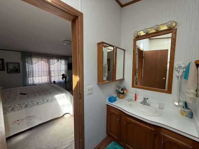 bathroom with vanity and wallpapered walls