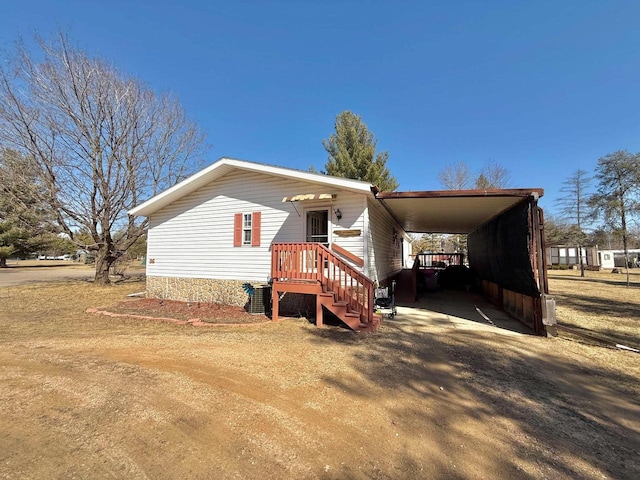 manufactured / mobile home featuring a carport and driveway