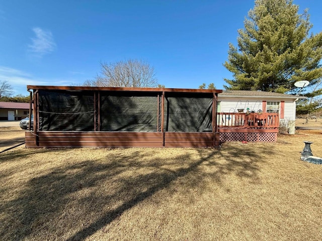 back of property featuring a lawn and a wooden deck