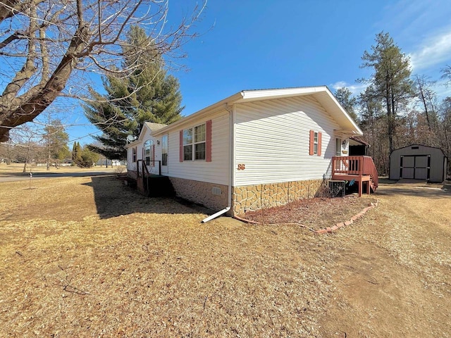 view of side of property featuring crawl space, an outdoor structure, and a shed