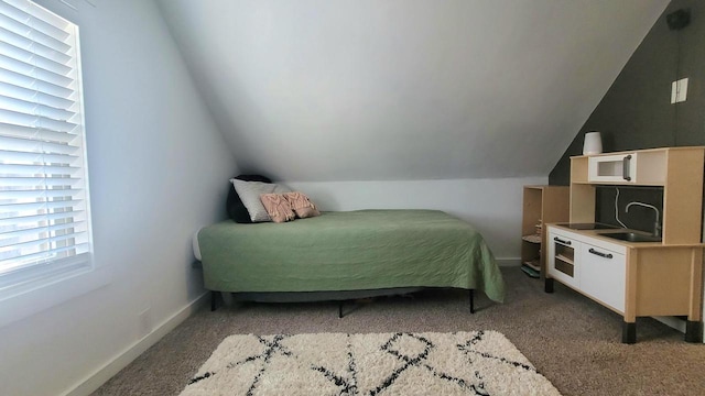 bedroom featuring a sink, baseboards, carpet, and vaulted ceiling