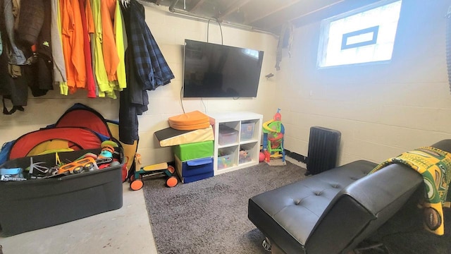 playroom with concrete flooring and concrete block wall