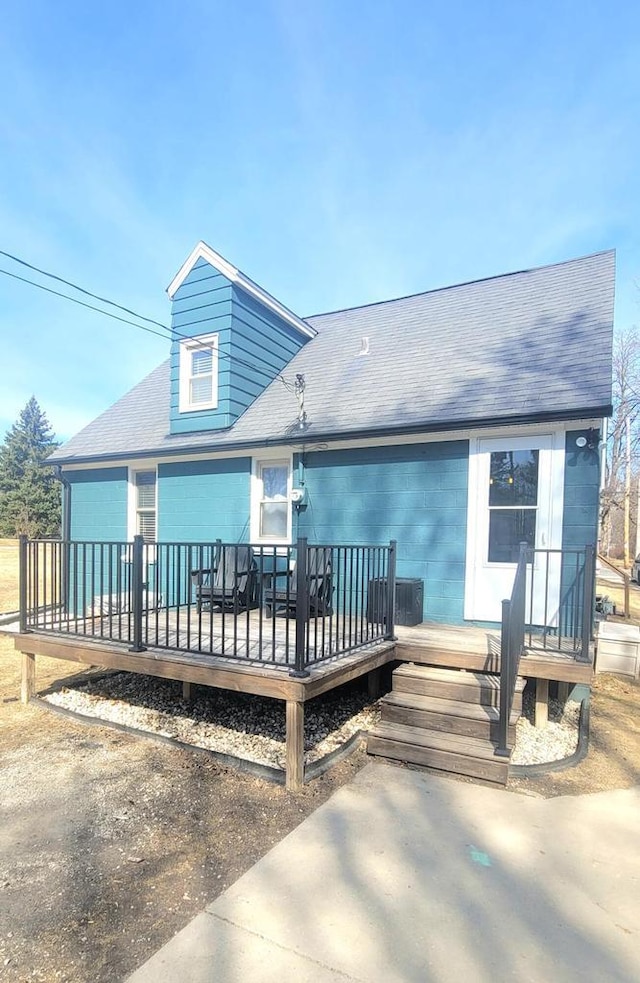 rear view of house with a shingled roof and a wooden deck