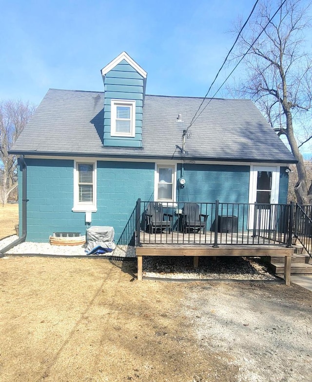 rear view of property with a shingled roof and a wooden deck