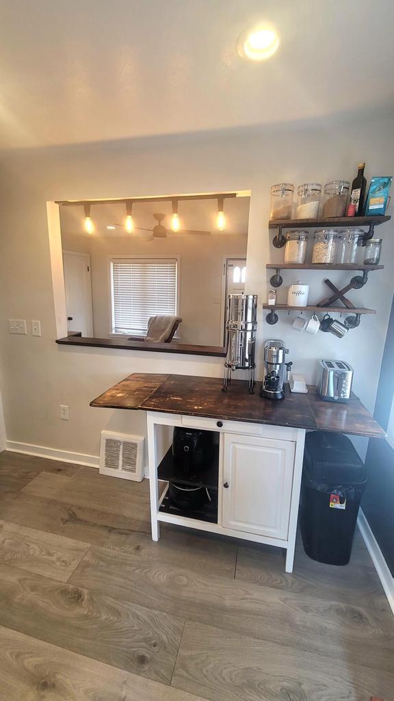 kitchen with visible vents, white cabinets, baseboards, and dark wood-style flooring