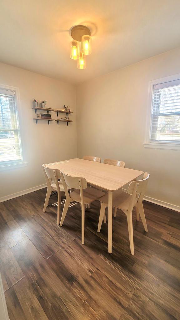 dining area with baseboards and dark wood-style flooring