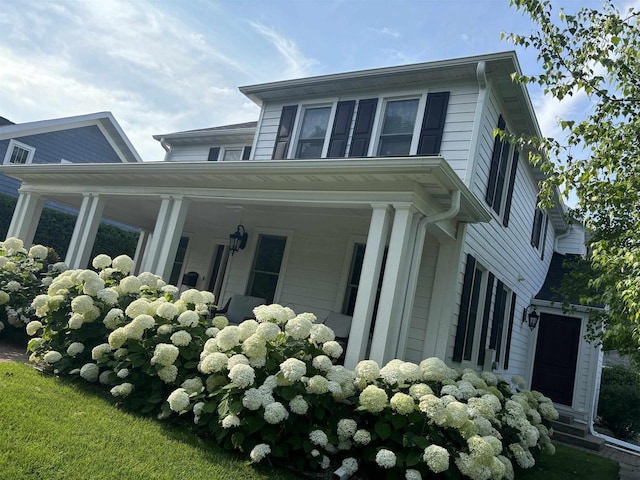 view of side of home featuring covered porch