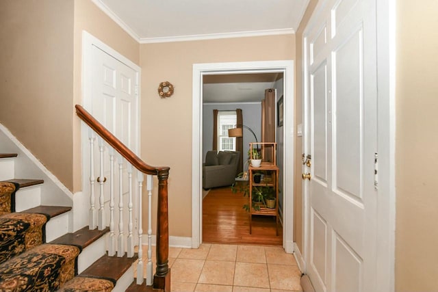 entryway featuring stairs, crown molding, light tile patterned floors, and baseboards