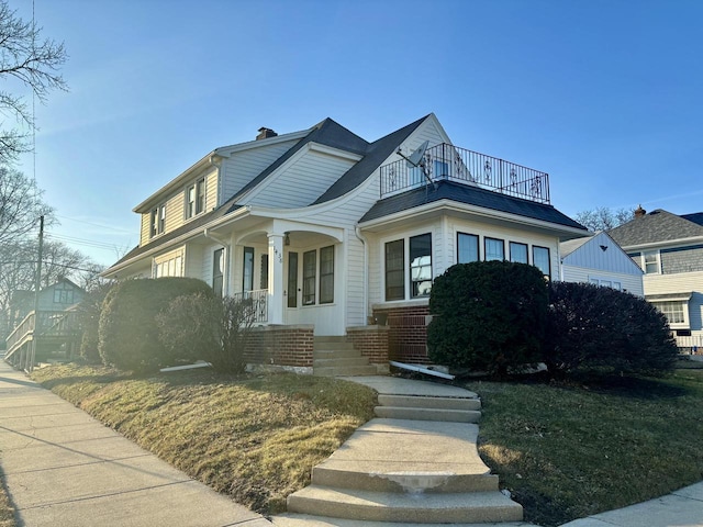 view of front of property with a balcony and a chimney