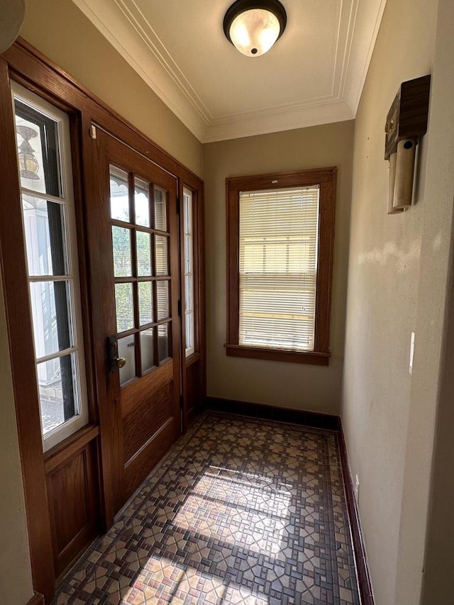 doorway featuring baseboards and ornamental molding