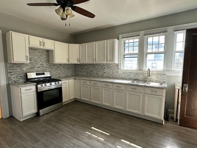 kitchen featuring dark wood-type flooring, backsplash, stainless steel range with gas cooktop, and a sink