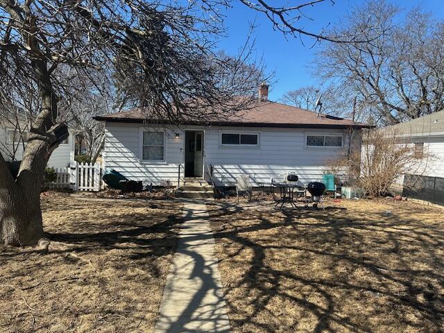 back of property with entry steps and fence