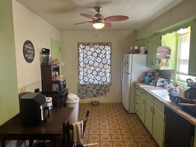 kitchen featuring tile patterned floors, a ceiling fan, black dishwasher, green cabinets, and light countertops