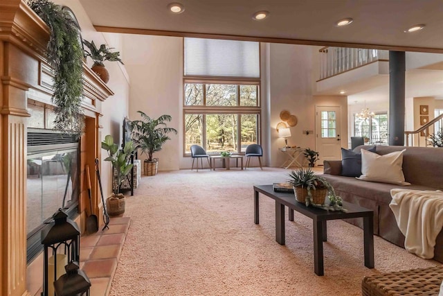 living area with recessed lighting, a high ceiling, an inviting chandelier, and carpet floors