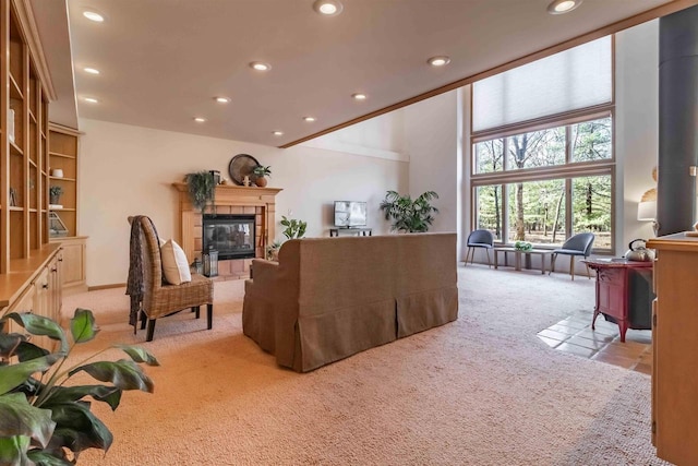 living room featuring a tiled fireplace, recessed lighting, light colored carpet, and a towering ceiling