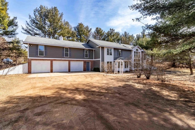 view of front of property with a garage, a chimney, and dirt driveway