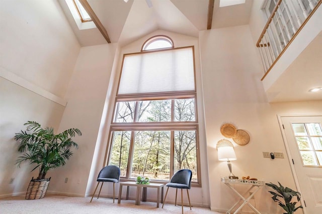 living area with plenty of natural light, high vaulted ceiling, and carpet