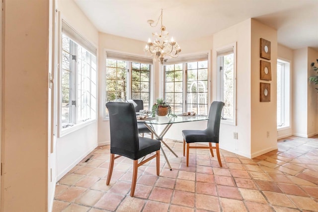 dining area with visible vents, baseboards, a healthy amount of sunlight, and an inviting chandelier