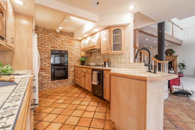 kitchen with a glass covered fireplace, tile countertops, light brown cabinets, and black appliances