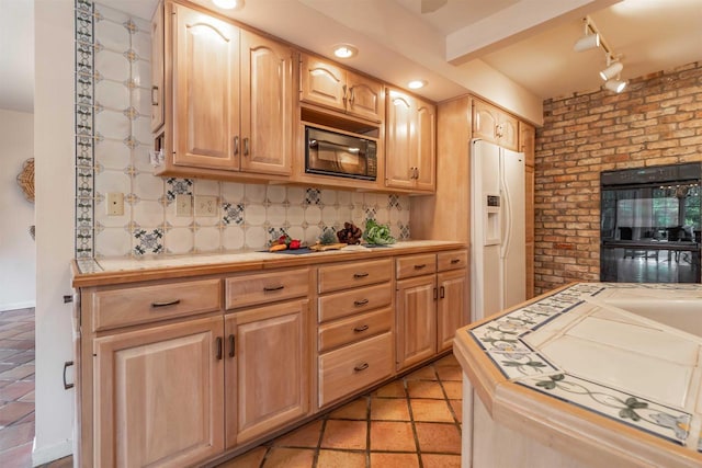 kitchen with light brown cabinets, brick wall, decorative backsplash, black appliances, and tile counters