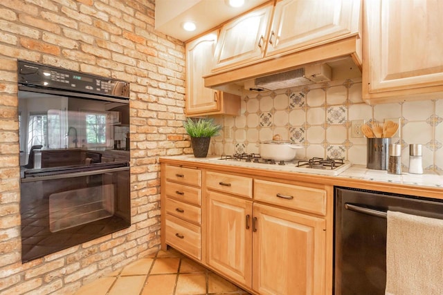 kitchen featuring backsplash, white gas stovetop, tile counters, light brown cabinetry, and dobule oven black