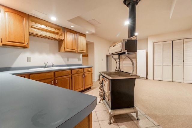 kitchen with a sink, light carpet, and recessed lighting