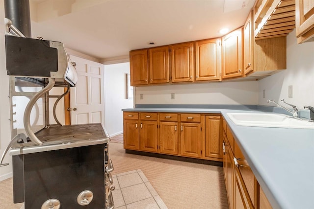 kitchen featuring brown cabinetry, baseboards, and a sink