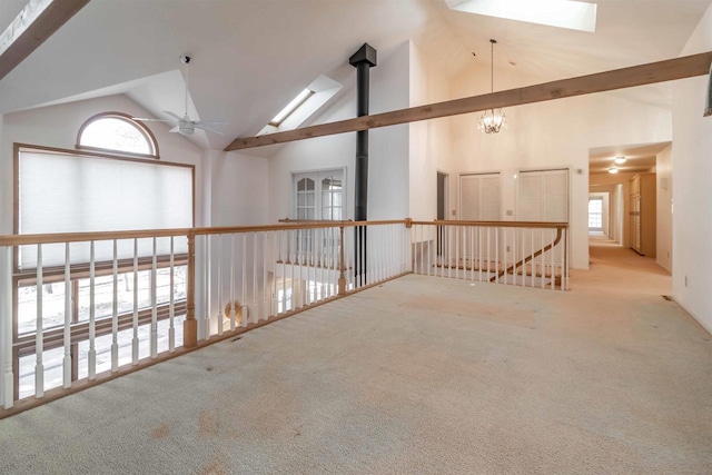 interior space with ceiling fan with notable chandelier and high vaulted ceiling