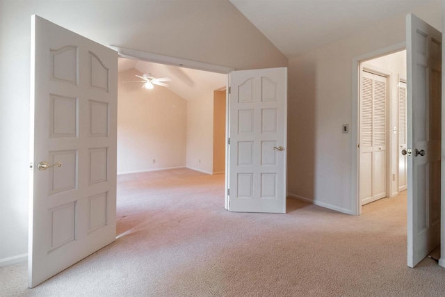 unfurnished room featuring baseboards, light colored carpet, a ceiling fan, and lofted ceiling