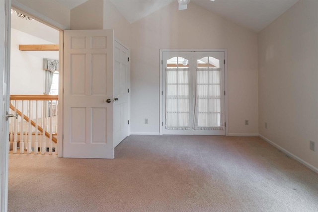 spare room featuring baseboards, lofted ceiling, and carpet