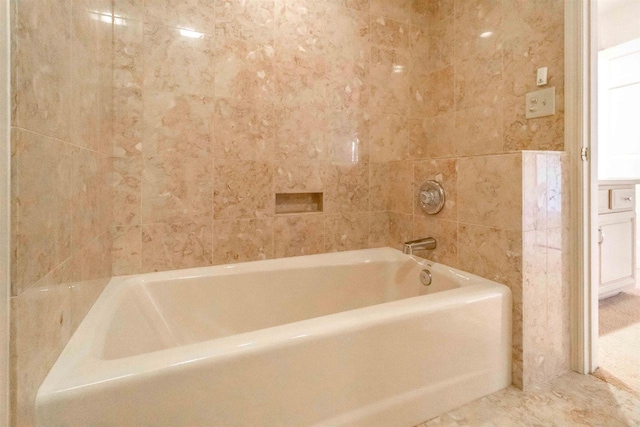 bathroom with a tub and tile walls