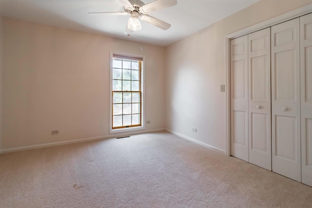 unfurnished bedroom with carpet, baseboards, a closet, and ceiling fan