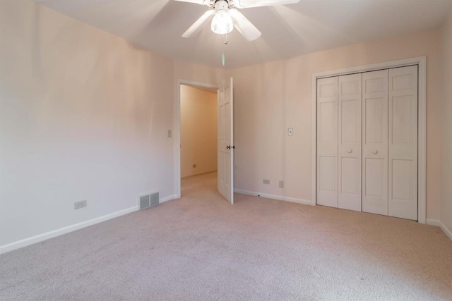 unfurnished bedroom with ceiling fan, baseboards, visible vents, and light carpet