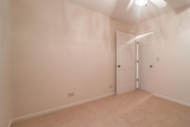 carpeted empty room with ceiling fan and baseboards