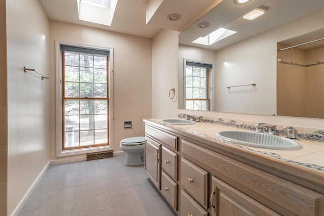 bathroom with a sink, toilet, and a healthy amount of sunlight