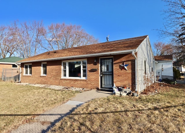 single story home with brick siding and a front yard