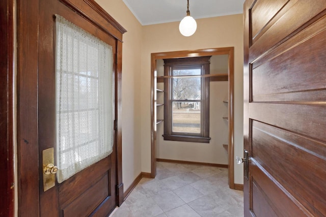 foyer with crown molding and baseboards