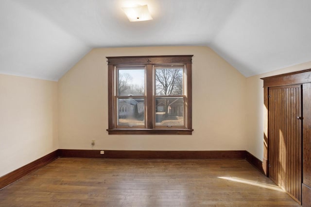 bonus room featuring hardwood / wood-style floors, vaulted ceiling, and baseboards