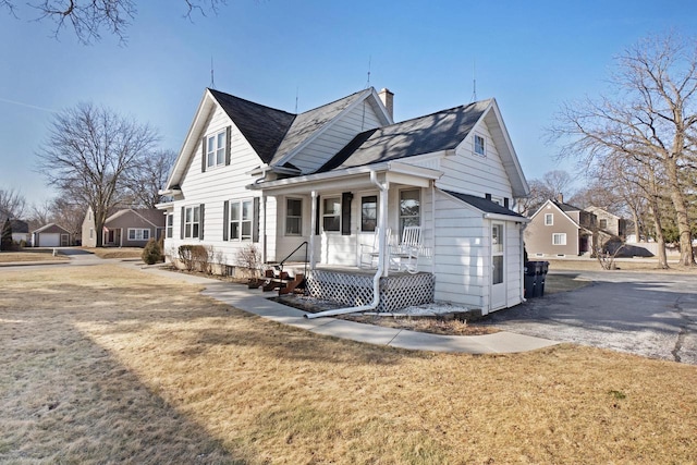 view of property exterior featuring a yard, covered porch, and a chimney