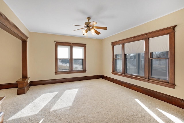 empty room with a ceiling fan, baseboards, and carpet floors