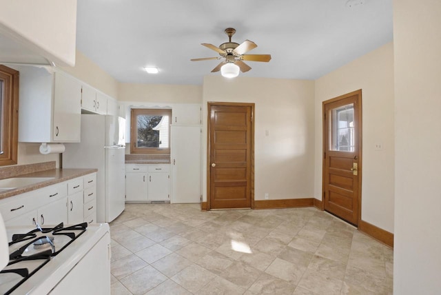 kitchen with white cabinets, white appliances, light countertops, and baseboards