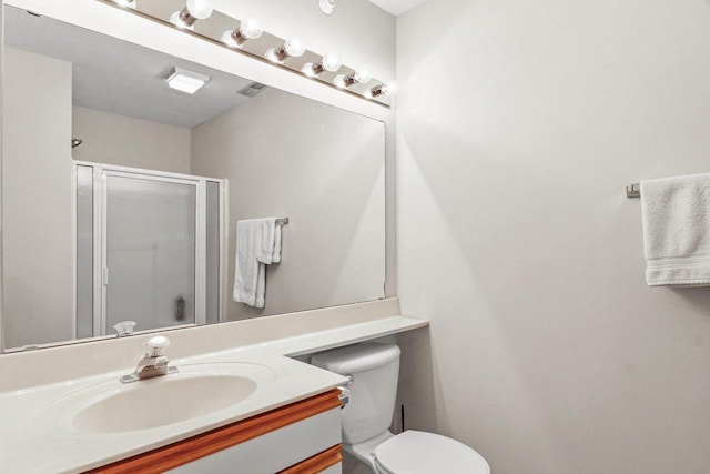 bathroom with vanity, toilet, visible vents, and a stall shower