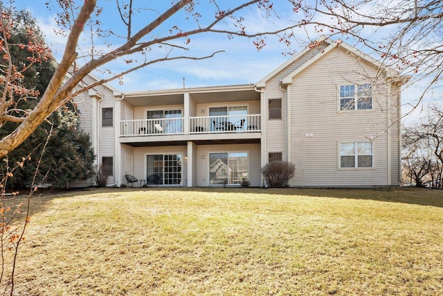 back of house with a yard and a balcony