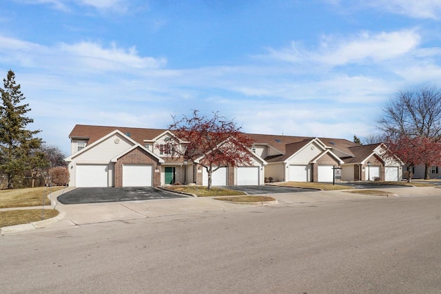 view of front of house featuring brick siding, a residential view, and driveway