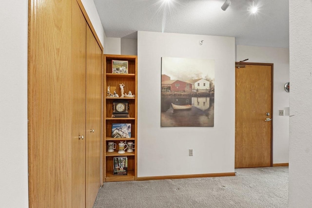 hallway featuring baseboards and carpet flooring