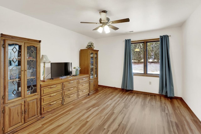 bedroom with a ceiling fan, visible vents, baseboards, and light wood finished floors