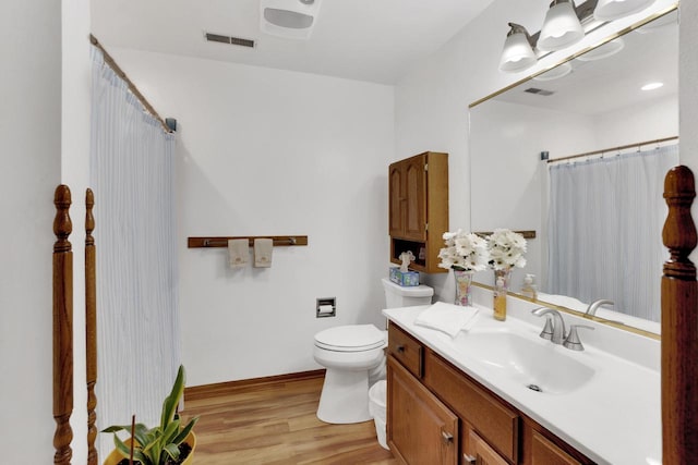 full bath with visible vents, toilet, vanity, and wood finished floors