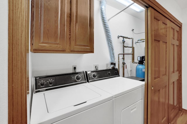 washroom with cabinet space and washer and clothes dryer